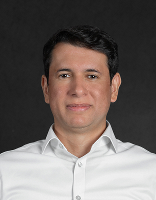 Erick Arruda, with dark hair, wearing a light-colored shirt, slightly smiling, looking forward.