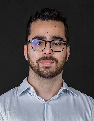 João Pedro Coelho, man with dark hair, beard, rectangular glasses, light-colored shirt, neutral expression, Analyst.