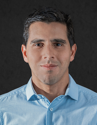 João Sá, man with short dark hair, light blue dress shirt, smiling, looking forward.