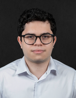 Luiz Nascentes, intern, with dark curly hair, black-framed glasses, wearing a light gray dress shirt, neutral expression.