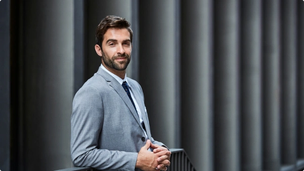 Retrato de profissional de terno cinza em ambiente corporativo, representando o time de gestão do fundo.